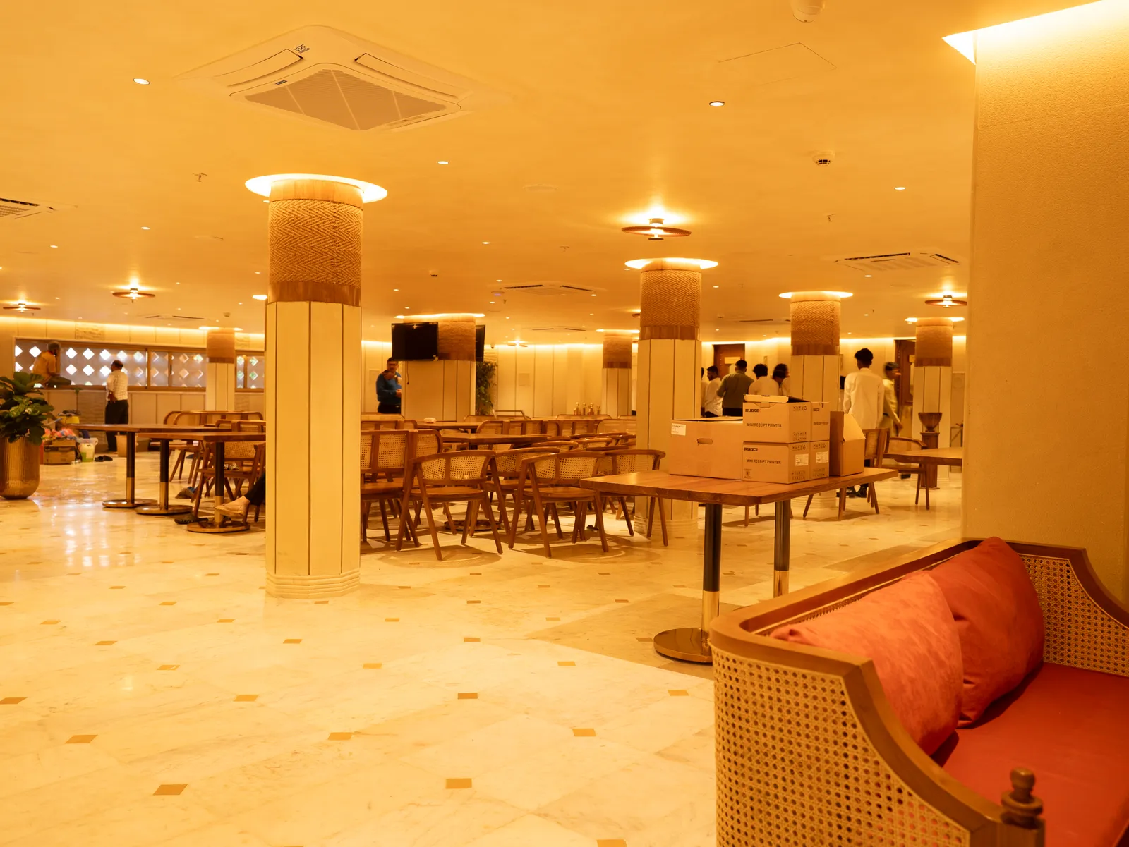 Restaurant dining hall with cane seating and pillar lighting — Chalukya Samrat